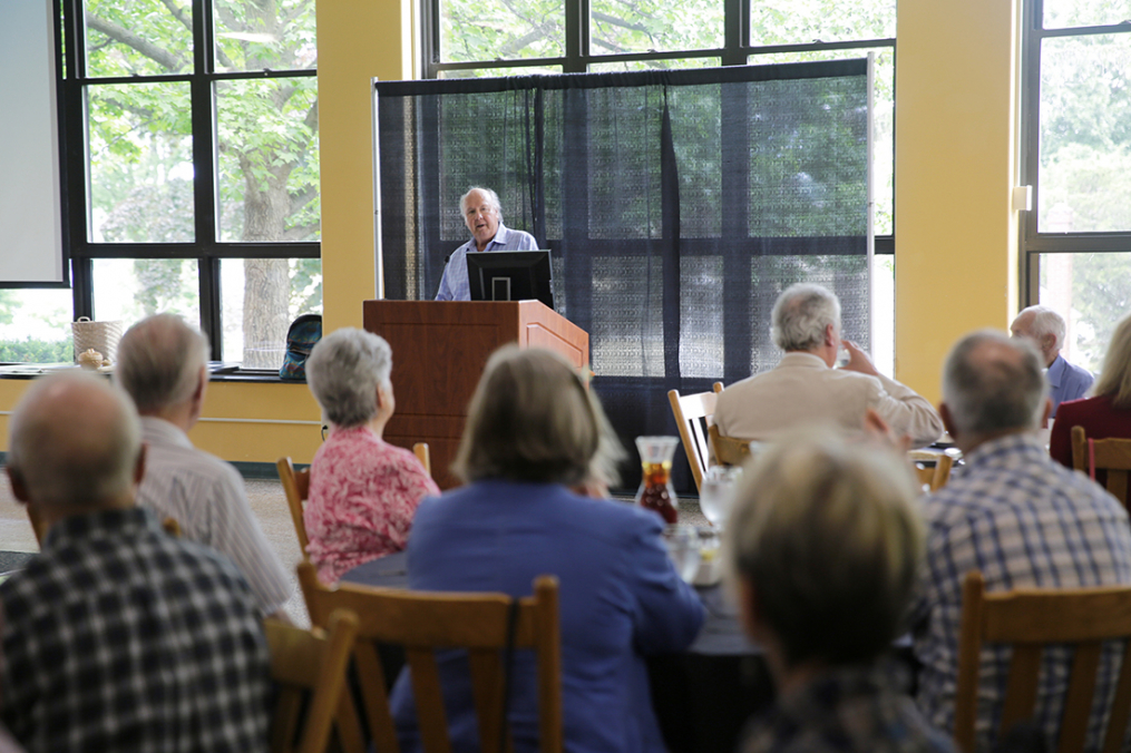 man speaking at a podium in front of a crowd